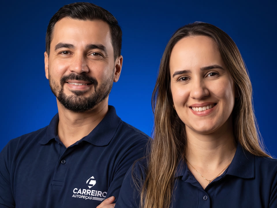 Os donos da Carreiro Auto Peças sorrindo, vestindo a camisa polo azul da empresa